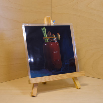 A 6x6" fine art print of the original acrylic painting "Caesar" by Hannah Kilby from Hannah Michelle Studios. Displayed in a protective plastic sleeve on a small, wooden easel.